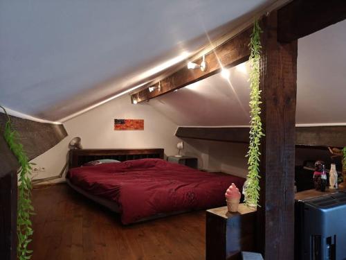une chambre avec un lit avec une couette rouge dans l'établissement Atelier d’artiste proche Paris Gare nord/Stade de FR/CDG, à Stains