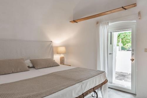 Trulli-Mestandrea al poggio piscina uso esclusivo في نوتشي: غرفة نوم بيضاء بها سرير ونافذة