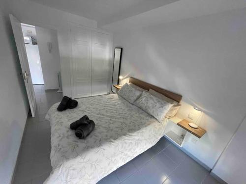 Un dormitorio con una cama con dos bolsas negras. en Las Carmenes 2, en El Médano