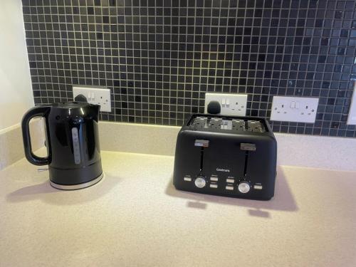 a toaster sitting on a counter next to a coffee pot at Superior Cambridge 2 Bed Apartment inc King Bed in Trumpington