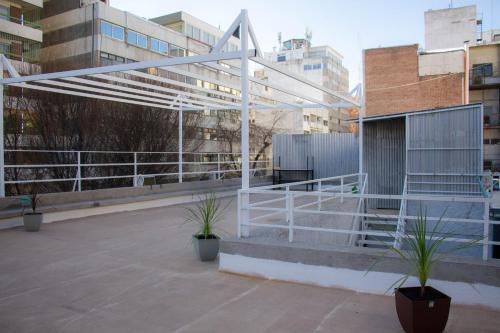 a white metal structure in a city with buildings at Sin Fin Hostel in Mendoza