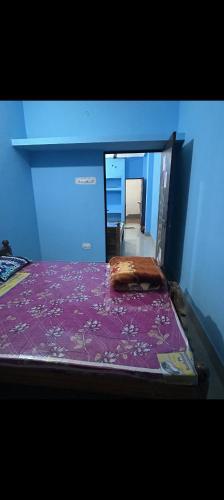 a bedroom with a bed with a purple bedspread at MAA MANSHA GUEST HOUSE in Deoghar