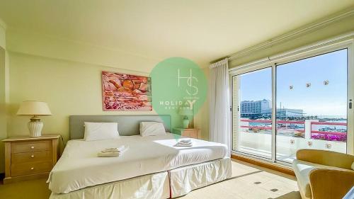 a bedroom with a large bed and a large window at YES Vista Marina T1 by HsR Vilamarina in Quarteira