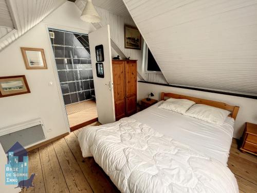 een slaapkamer met een groot wit bed op een zolder bij Echappée en Baie de Somme - vue magnifique sur la Baie in Saint-Valery-sur-Somme