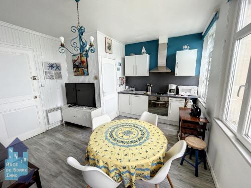 une salle à manger avec une table et une cuisine dans l'établissement Echappée en Baie de Somme - vue magnifique sur la Baie, à Saint-Valery-sur-Somme