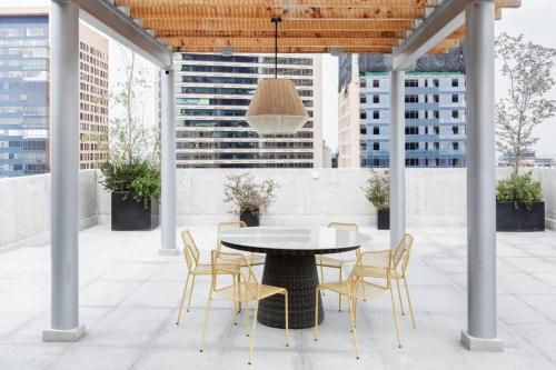 a table and chairs on a patio with a ceiling at Cómodo departamento en Polanco. Pool, gym & garage in Mexico City
