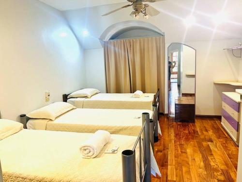 a room with three beds and a ceiling fan at Casona en Buenos Aires in Buenos Aires