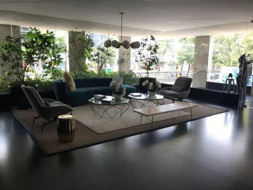 a living room with a blue couch and chairs at Cómodo departamento en Polanco. Pool, gym & garage in Mexico City
