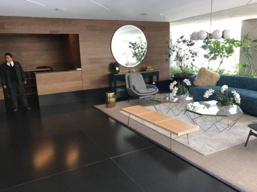 a man in a suit standing in a living room at Cómodo departamento en Polanco. Pool, gym & garage in Mexico City