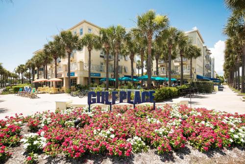 a park with chairs and flowers in front of a building at Lazy Daze at Gulf Place 208 in Santa Rosa Beach
