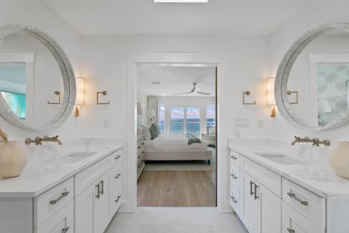 a white bathroom with two sinks and a bedroom at Beachside Bungalow in Destin