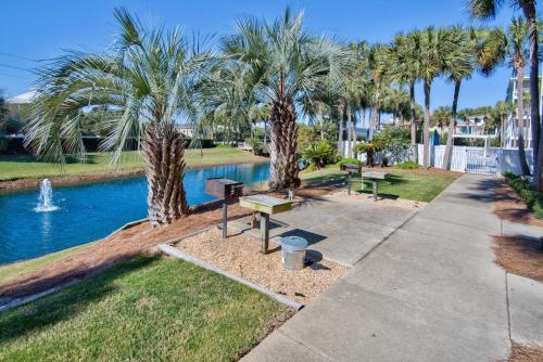 a park with benches and palm trees next to a pool at Lazy Daze at Gulf Place 208 in Santa Rosa Beach