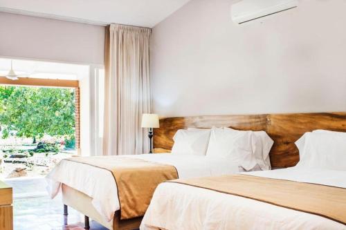 2 Betten in einem Hotelzimmer mit Fenster in der Unterkunft OPacifico Hotel Boutique in Naranjo