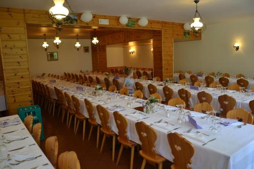 um grupo de mesas e cadeiras num salão de banquetes em ALBERGO VALLUNGA em Tartano