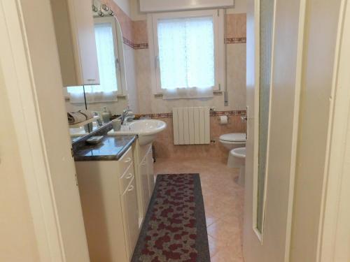 a bathroom with two sinks and a toilet and a window at Casa dolce casa in Aviano