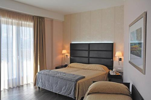 um quarto de hotel com duas camas e uma janela em S Hotel em San Giovanni Teatino