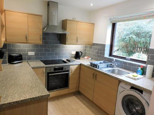 a kitchen with a sink and a washing machine at 2 bed Apt on Quiet Cul-de-Sac, Fab Location in Paisley