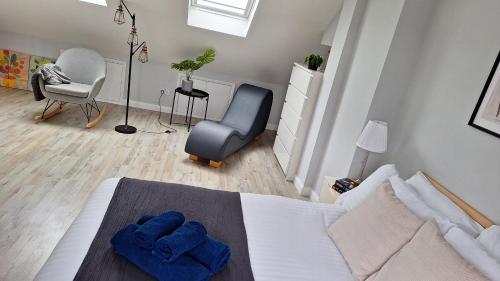 a bedroom with blue towels on a bed and a chair at NEW 2 bedrooms with private ensuite bathrooms near Heathrow in Ashford