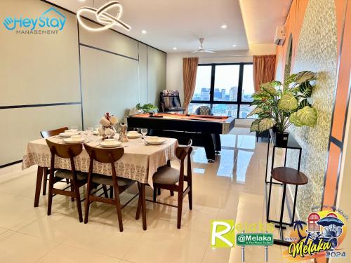 a dining room with a table and a piano at The Apple Residence By Heystay Management in Melaka