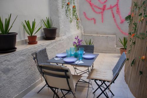 een tafel en stoelen op een patio met planten bij Moon Haven Near Acropolis in Athene