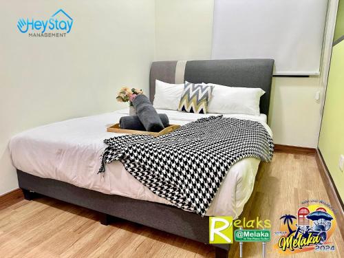 a bedroom with a large bed with a dog sitting on it at The Apple Residence By Heystay Management in Melaka