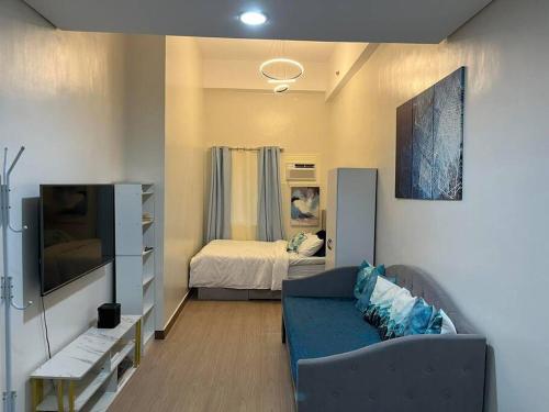 uma sala de estar com um sofá e uma cama em Athena's Place - Hope Residences SMDC Trece Cavite em Trece Martires