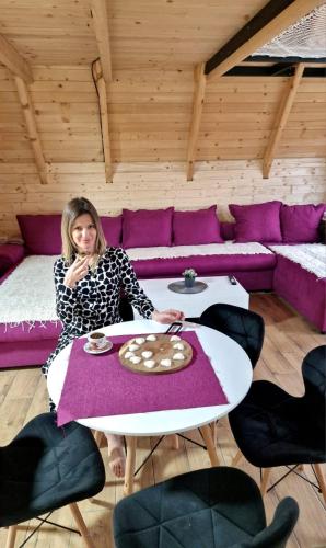a woman sitting at a table in a room at Vila Homoljska Idila Banja Zdrelo in Ždrelo