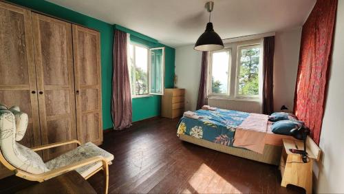 a bedroom with green walls and a bed and a chair at naturel home in Adalar