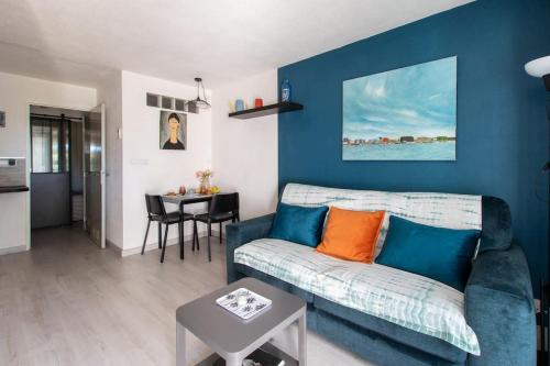 un salon bleu avec un canapé et une table dans l'établissement Le bleu horizon * Terrasse * clim * Parking * wifi * Calme * Cosy, à La Grande Motte