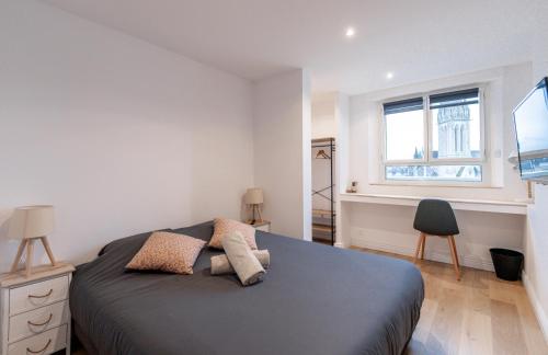une chambre avec un lit, un bureau et une fenêtre dans l'établissement Appt premium Centre Château terrasse 2 chambres 6p vue exceptionnelle, à Caen