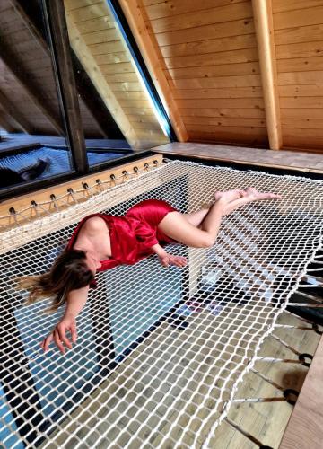 a woman laying on top of a metal net at Vila Homoljska Idila Banja Zdrelo in Ždrelo