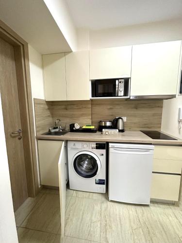 a kitchen with a washing machine and a microwave at Navarino Luxe Suites in Perea