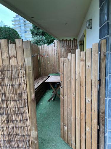 a wooden fence with a picnic table and a bench at Appartement T2 Bayonne-Anglet in Bayonne