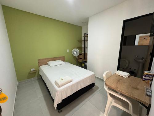 a bedroom with a bed and a table with a mirror at Hotel La Central Belalcazar Palmira in Palmira