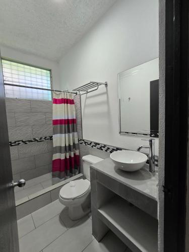 a bathroom with a toilet and a sink at Tropical Paradise in Jacó