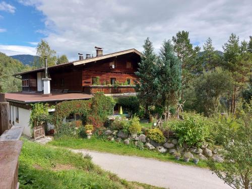 a wooden house with a garden in front of it at Naturetouch in Steinberg am Rofan