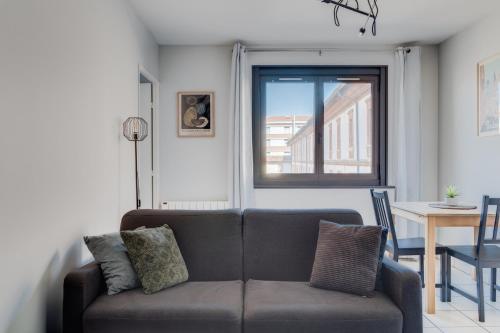 un salon avec un canapé et une table dans l'établissement Bologne by Yumē, à Toulouse