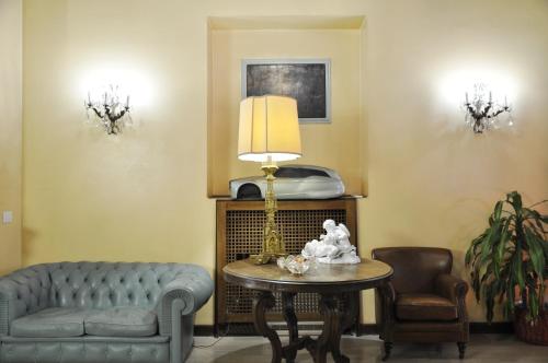 a living room with a couch and a table with a lamp at Hotel San Guido in Milan