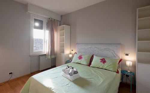 ein Schlafzimmer mit einem großen Bett mit grünen und rosa Kissen in der Unterkunft Borgo di Parma in Parma