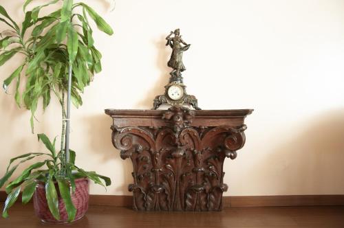 a grandfather clock sitting on a table next to two plants at Hotel San Guido in Milan