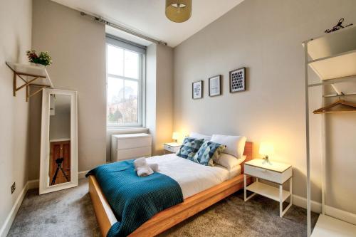 Un dormitorio con una cama grande y una ventana en Stylish & Spacious 3 Bedroom Apt in Finnieston, West End, en Glasgow