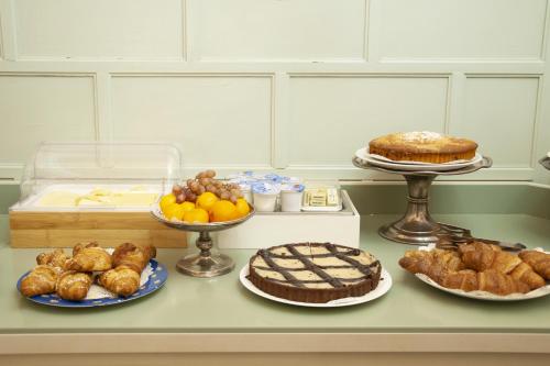 a table with different types of cakes and pastries at Hotel San Guido in Milan