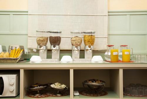 a shelf with several glass containers of food and drinks at Hotel San Guido in Milan