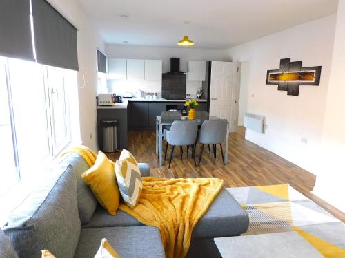 a living room and kitchen with a couch and a table at Newly refurbished 2 bedroom apartment close to station and local amenities in Hamilton