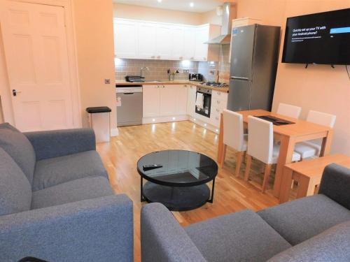 a living room with a couch and a table and a kitchen at Beautiful 3 bed apt in the City Centre in Glasgow