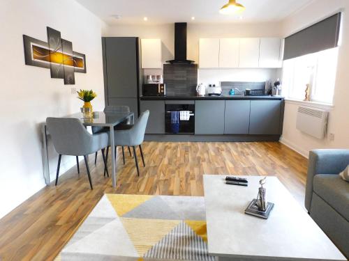 sala de estar y cocina con mesa y sillas en Newly refurbished 1 bed Apt in Hamilton Close to station and local amenities en Hamilton