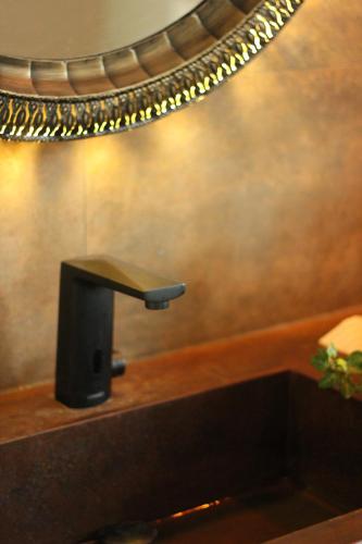 a bathroom sink with a faucet and a mirror at La Casa del Cantero in Pinilla del Valle