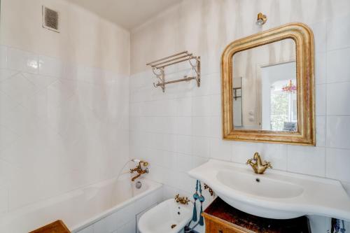 une salle de bain avec un lavabo, un miroir et une baignoire dans l'établissement Brienne by Yumē, à Toulouse