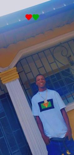 a man standing in front of a building with hearts on the ceiling at Ekerejebor in Ughelli