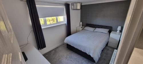 a small bedroom with a bed and a window at Beautiful 2 bed house close to M74 and Strathclyde Park in Motherwell